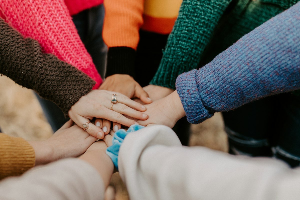 Grupo de amigos unindo as mãos, ideia de comunidade